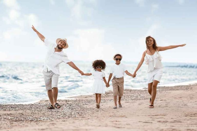 Familie läuft zusammen am Strand entlang